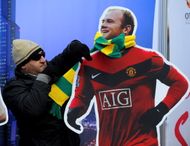 A Manchester United fan places a green and gold scarf around a cut-out of Wayne Rooney before the Barclays Premier League match between Manchester United and Fulham at Old Trafford on March 14, 2010 in Manchester, England. (Getty Images)